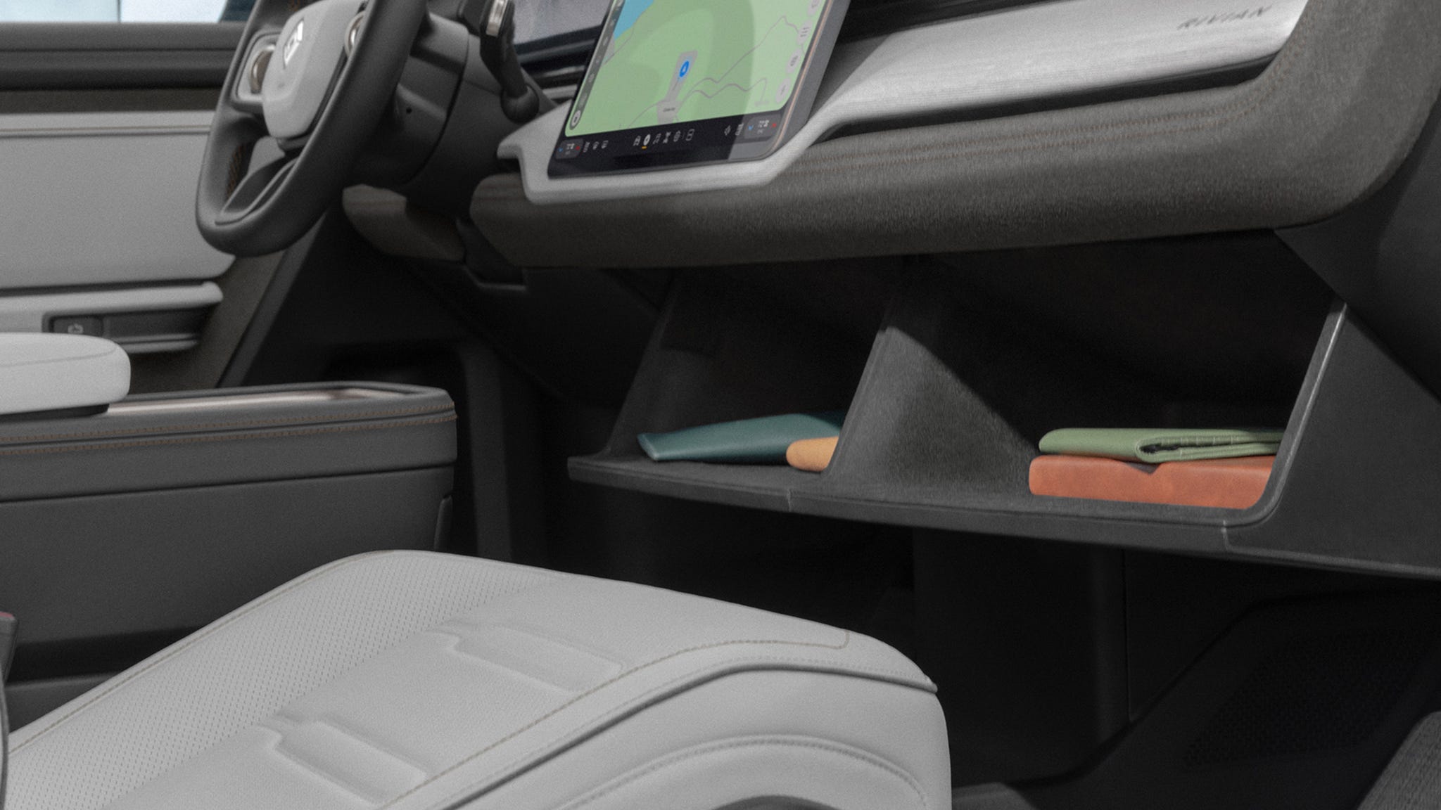 Car interior with touchscreen, steering wheel, and storage cubby.