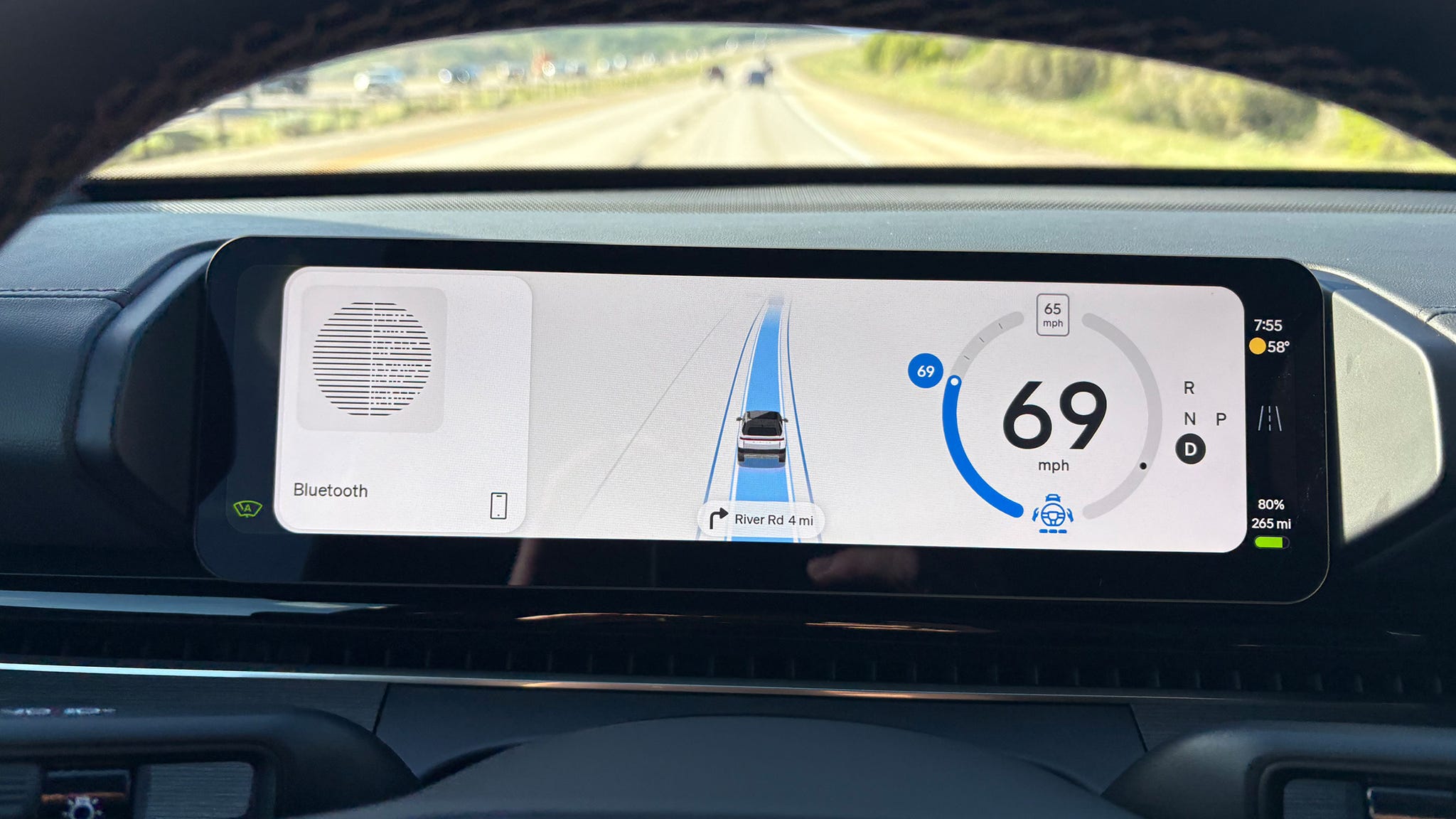 Digital dashboard showing 69 mph, lane assist, navigation, and Bluetooth.