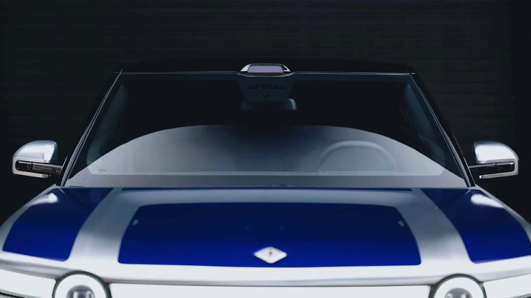Front view of a stylish modern car with a blue hood and silver side mirrors.