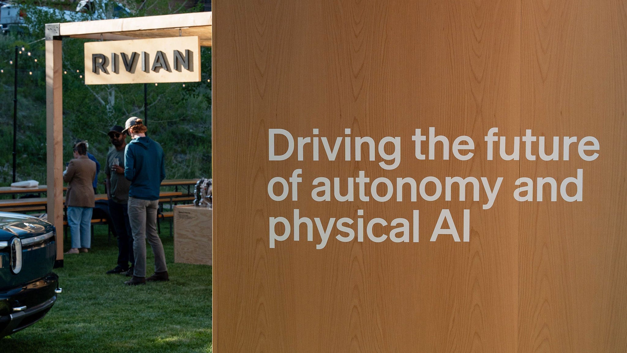 Sign reading "Driving the future of autonomy and physical AI" next to Rivian booth.